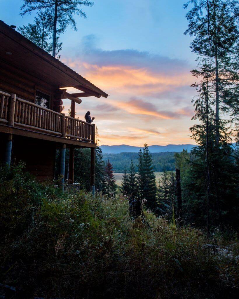 woman sipping coffee from a deck at sunrise