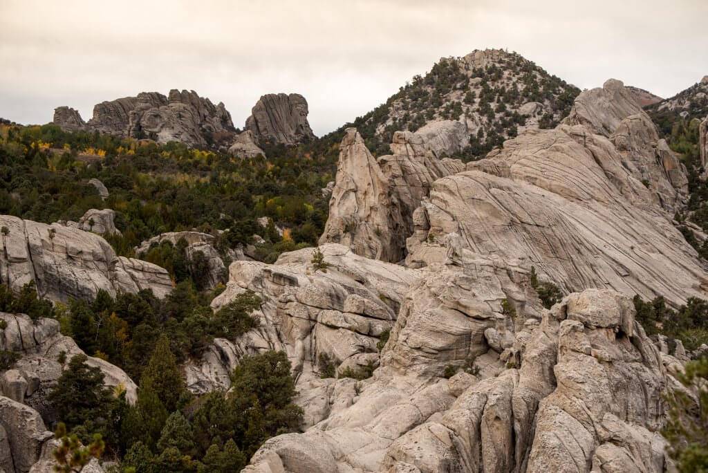 landscape shot of rugged and jagged rock formations with scattered trees and sagebrush