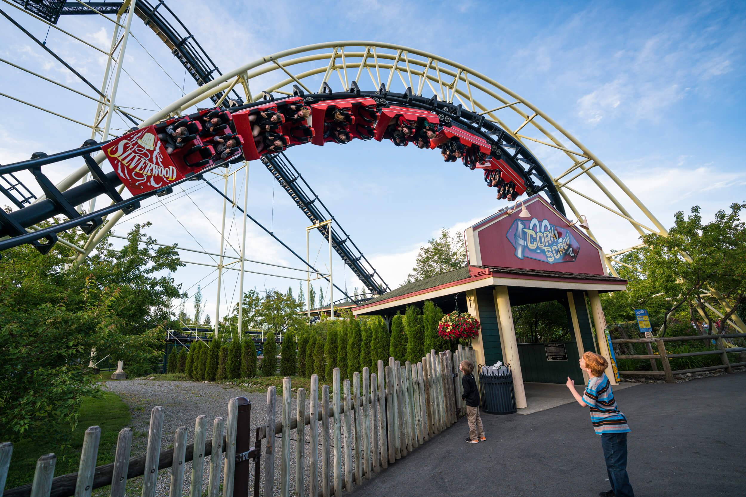 Two boys watch people ride a twisting roller coaster at Silverwood Theme Park.