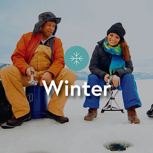 A couple ice fishing together in the winter.