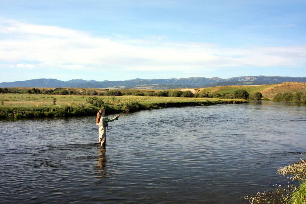 A woman dressed in waders casts a line into the Middle Fork of the Salmon River.