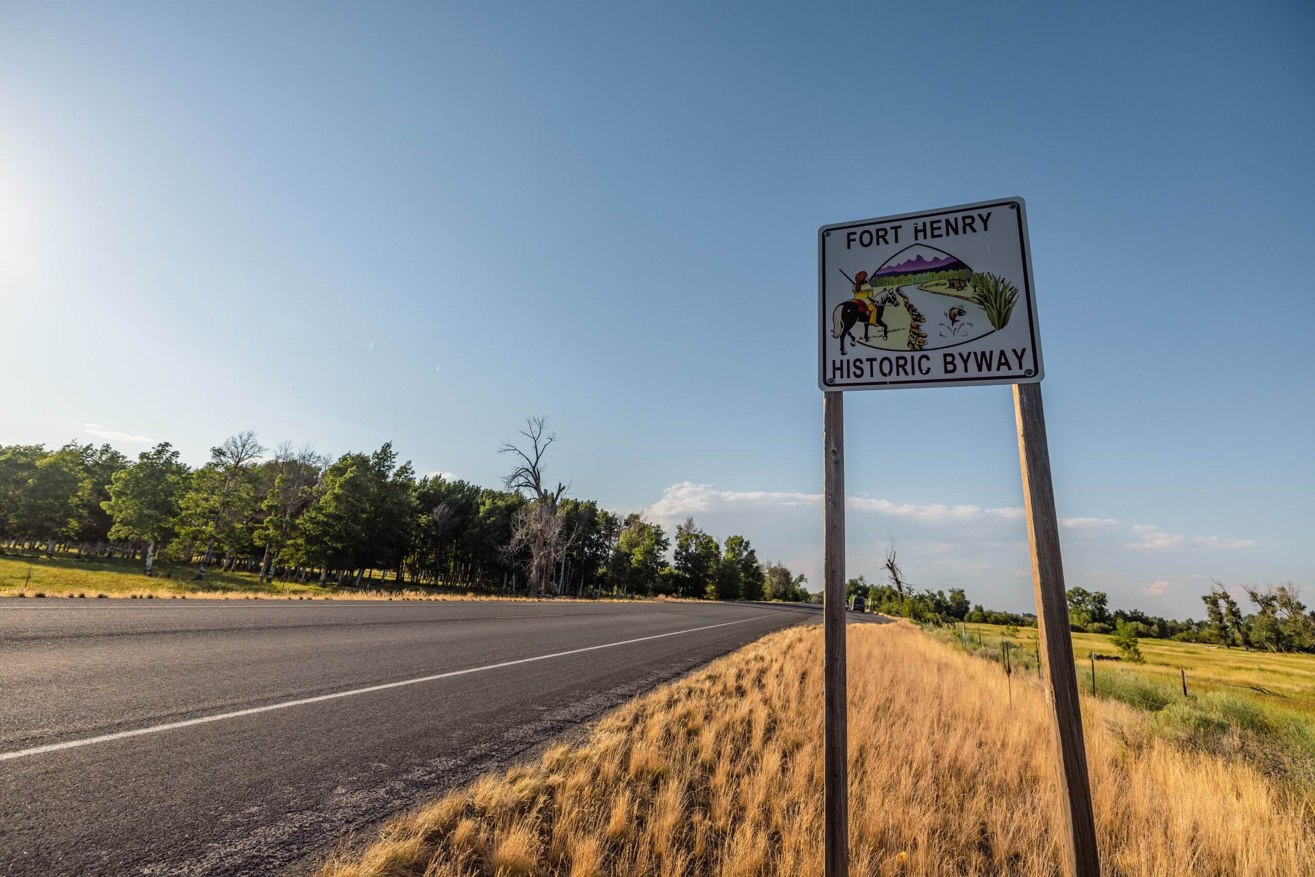 a road sign that reads "fort henry historic byway" along a road lined by trees