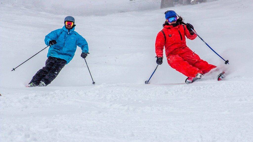 A couple in snow gear skiing at Pebble Creek Ski Area.