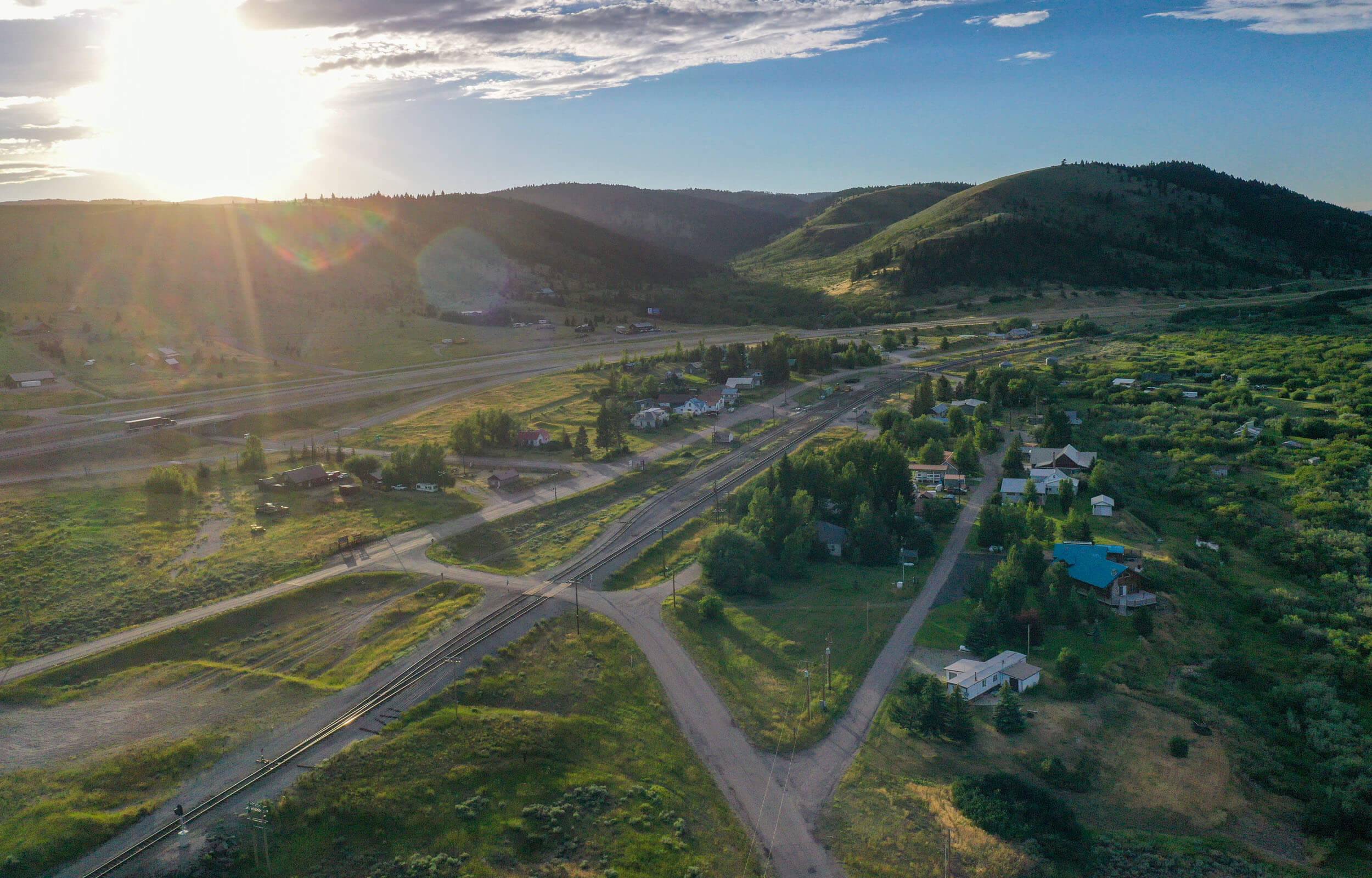 Aerial view of the town of Spencer, with trees and buildings, and mountains in the background.