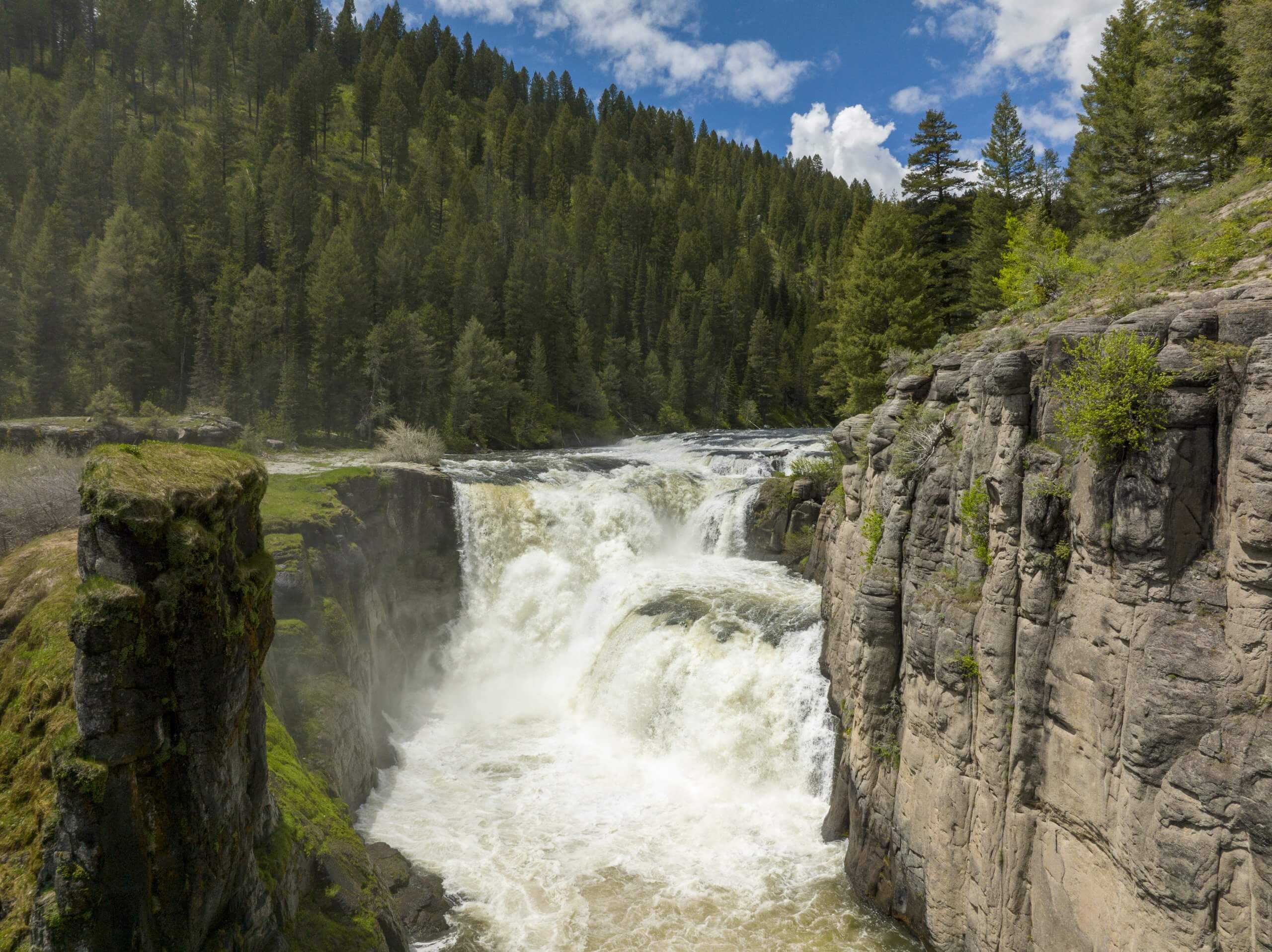 An aerial shot of a large waterfall during full flow.