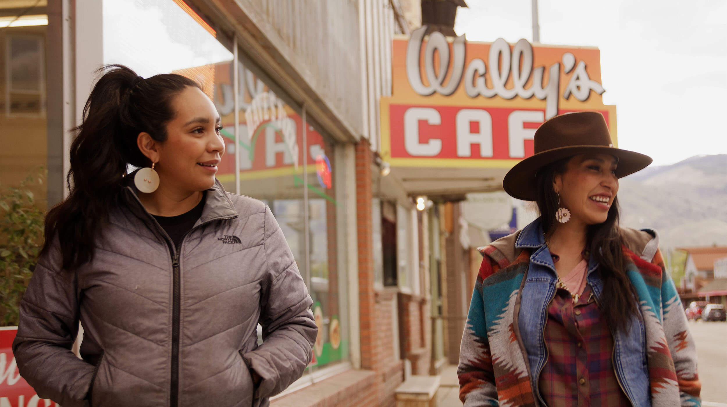 Two women walking on the sidewalk past retail stores in downtown Salmon.